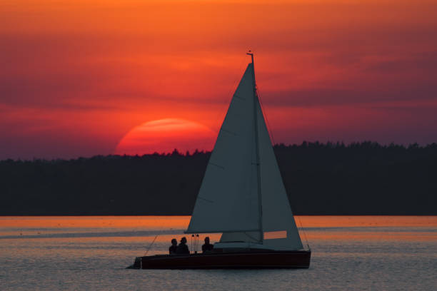 silhouette di yacht che navigano in uno spettacolare tramonto sul lago - steinhuder meer foto e immagini stock