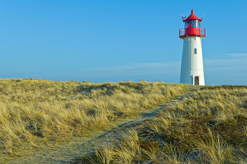 White lighthouse in dutch coastal village of Egmond aan Zee on a sunny summer day