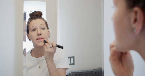 istock Young Woman Applying Foundation with a Brush 1300547184