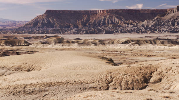 istock Drone Shot of Sand Dunes and Towering Sandstone Mesa 1300551998