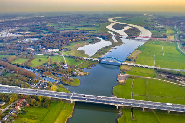 Lowland river IJssel with bridges Aerial view of huge lowland river IJssel with highway and railroad bridges through sunset landscape. Zwolle, Overijssel Province, the Netherlands. Drone scene in nature of Europe. netherlands aerial stock pictures, royalty-free photos & images