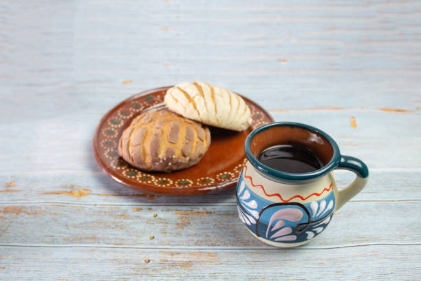 https://media.istockphoto.com/id/1300553467/photo/shells-traditional-mexican-bread-with-colorful-mexican-cup-for-cafe-on-vintage-boards.jpg?s=612x612&w=0&k=20&c=k-DCb8lWZCOvtDjFD5lX2rlc_Zx4rFQ5lNHWNcnqqDE=