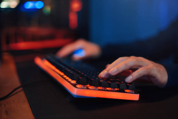 istock Hacker's or gamer's hands on keyboard in neon color 1300554475