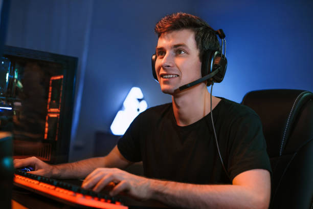 istock Smiling guy playing video online game on his computer at home 1300554862