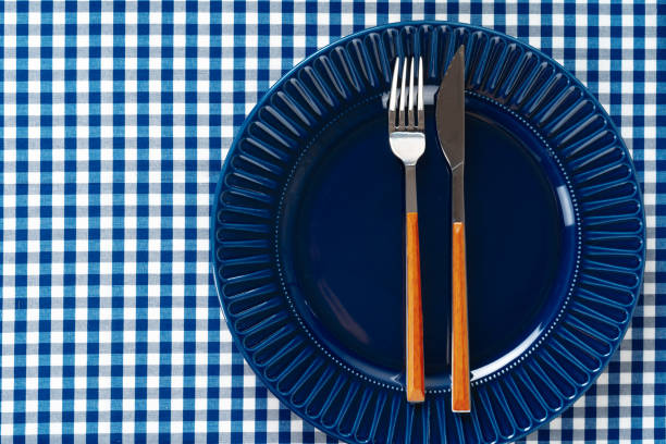 istock Deep blue ceramic plate with cutlery close up 1300555871