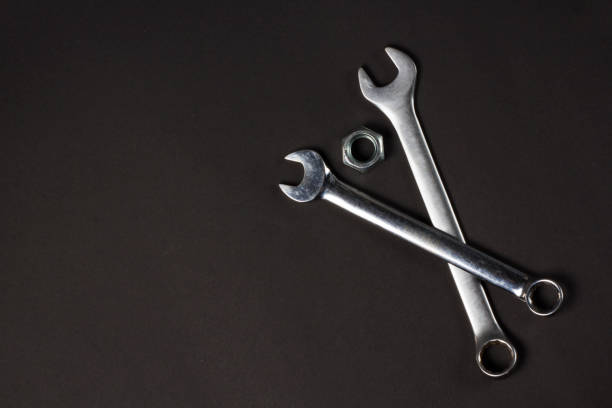 istock Two spanners and screw-nut on black background 1300557308