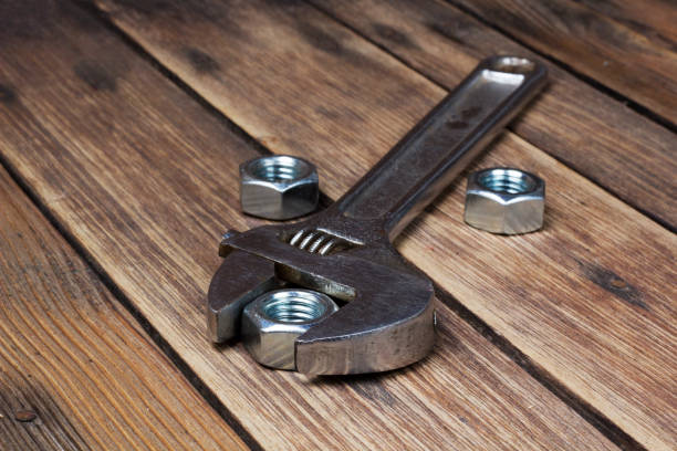 istock Wrench and screw-nuts on wooden planks 1300558094