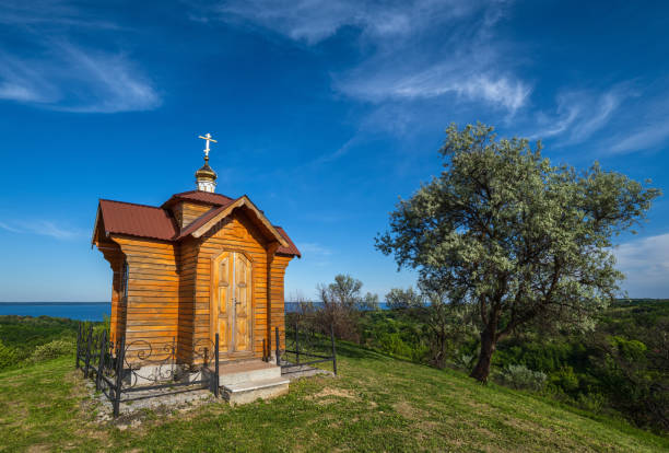 Dnipro river shores summer landscape. Small wooden chapel in Trakhtemyriv historical hilly peninsula on Kaniv water Reservoir Cherkasy Region, Ukraine. Dnipro river shores summer landscape. Small wooden chapel in Trakhtemyriv historical hilly peninsula on Kaniv water Reservoir Cherkasy Region, Ukraine. cherkasy stock pictures, royalty-free photos & images