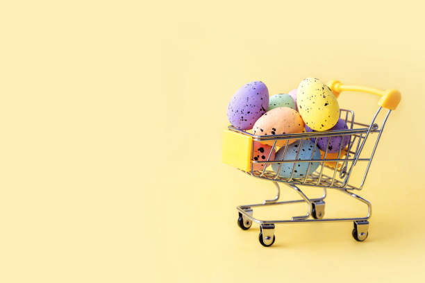 istock Colorful easter eggs in shopping cart on yellow background. Copy space. 1300559069