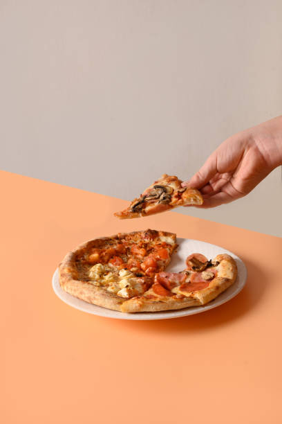 istock Child hand take Italian pizza with different ingredients on beige. 1300569623