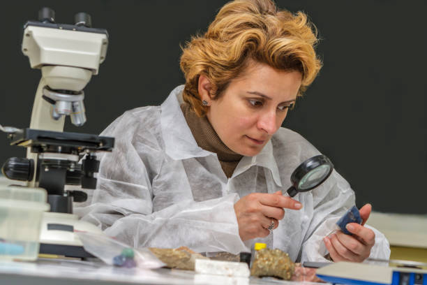 Geologist Researcher Working Female geologist researcher analyzing a rock at her workplace. soil tester stock pictures, royalty-free photos & images