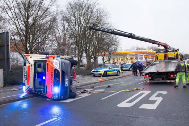 unfall auf einsatzfahrt - rettungswagen umgestürzt - bergung abschleppdienst - north rhine westfalia flash stock-fotos und bilder