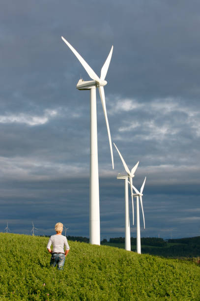 istock Woman looking at wind turbines. 1300572360