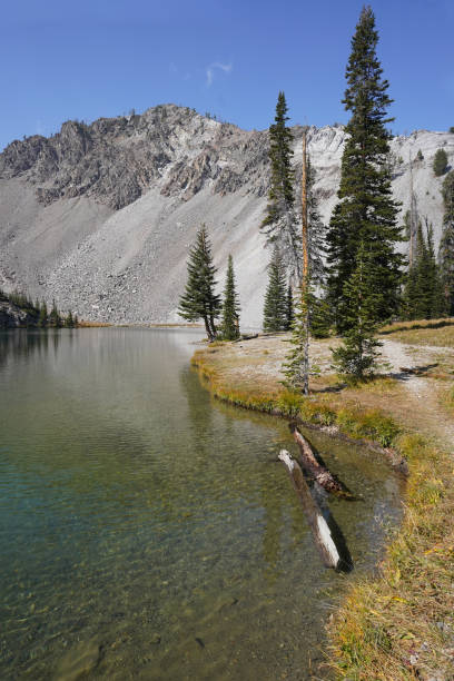 A hiking trail along a calm mountain lake. stock photo