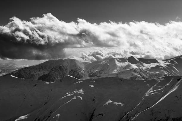 istock Evening snowy mountains and sunlight clouds at winter evening 1300582865