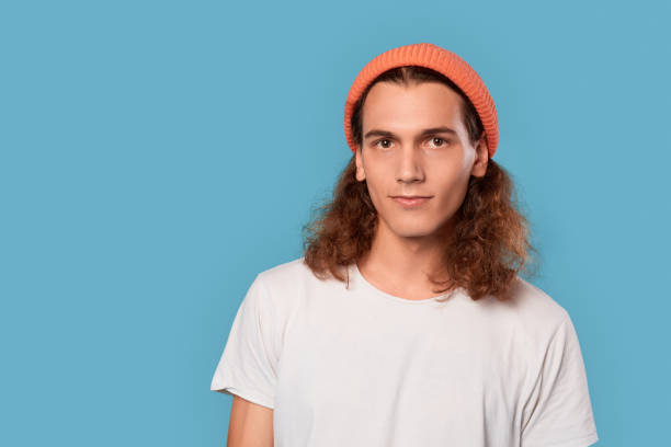 istock Young adult man looking at camera with calm face 1300582918