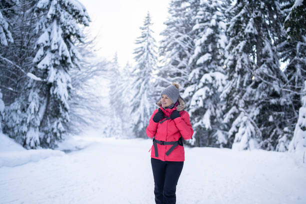 istock Woman with a backpack working in snow road in the forrest 1300582999