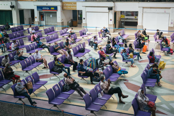 anwohner, die während der covid-19 pandemic am bahnhof bangkok auf einen zug warten - bangkok thailand asia temple stock-fotos und bilder