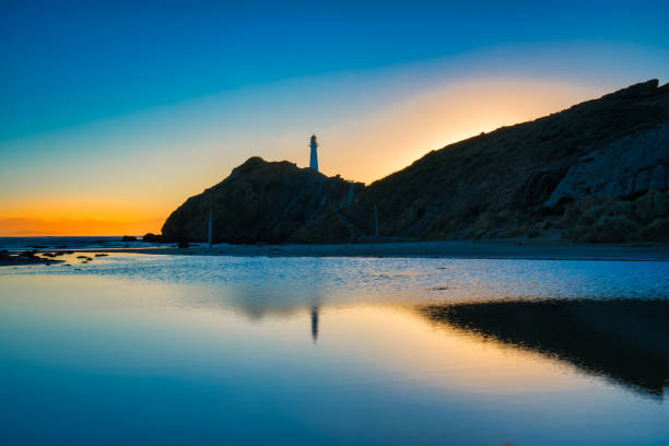 faro castlepoint reflejado en las aguas tranquilas de la laguna como el sol sale a primera luz - castlepoint fotografías e imágenes de stock