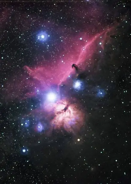 The Horsehead Nebula and Flame Nebula, located at the belt of the constellation Orion, the hunter.  Long exposure photo featuring rich hydrogen emission nebula, dark nebula and reflection nebula against a field of stars.