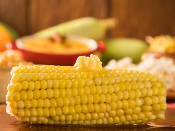 visão atenta sobre a espiga de milho dourado caseiro com manteiga derretida e sal sobre a mesa. - corn on the cob corn cooked boiled - fotografias e filmes do acervo