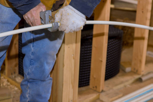 istock Plumbing building contractor cut a polypropylene pipe with scissors the hands of a worker in white gloves 1300610177