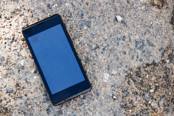 istock Mobile phone lies on the pavement closeup 1300616340