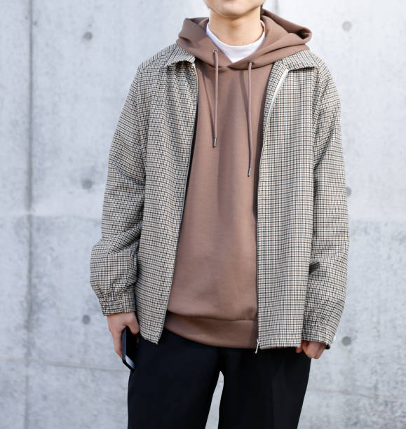 istock Young man holding a smartphone in front of a concrete wall 1300618465