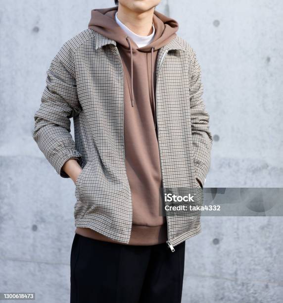 Young Man Standing In Front Of A Concrete Wall Stock Photo - Download Image Now - Menswear, Japanese Ethnicity, University Student