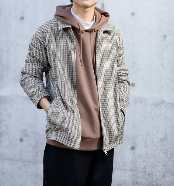 Young man standing in front of a concrete wall