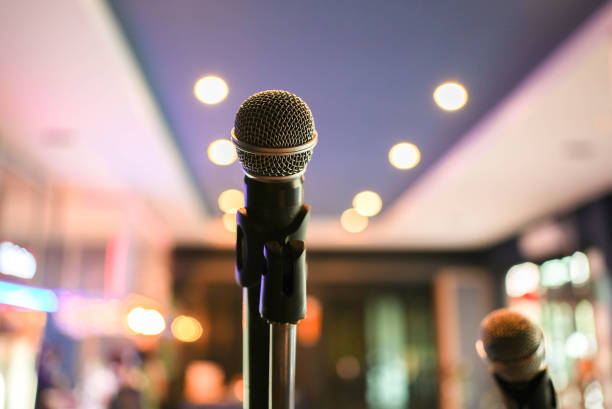 istock close up on black microphone standing on concert stage in the hall background for entertainment performance event concept 1300619614
