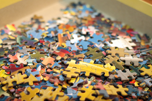 A photograph of jigsaw puzzle pieces in a box.