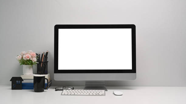 istock Front view of simple workspace with modern computer and office supplies. Blank screen for your text or advertising content 1300627264