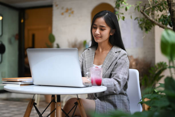 istock Young charming female freelancer thinking about new ideas during work on laptop computer at outdoor cafe. 1300627309