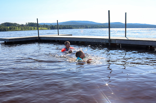 Boys playing in the water of Kalvsjön, Järvsö