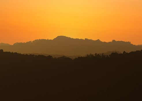 Distant hills during sunset, many layers of depth and color, from greys to orange, the place is the rolling hills in Chiba, Japan