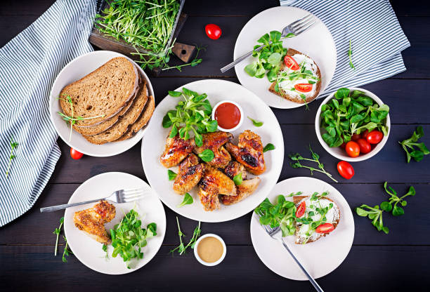istock Grilled chicken wings. Baked chicken wings on wooden table. Table setting. Top view, flat lay, overhead 1300629900