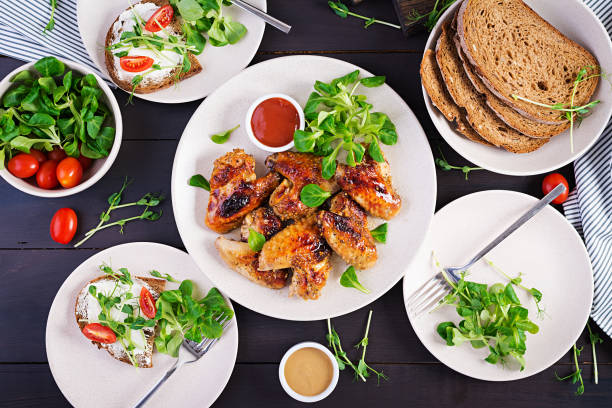 istock Grilled chicken wings. Baked chicken wings on wooden table. Table setting. Top view, flat lay, overhead 1300629904