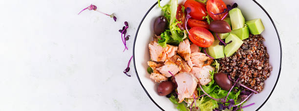 Salmon salad. Fresh salad with grilled salmon, avocado, cherry tomatoes, lettuce, quinoa, olive and microgreens. Homemade food. Concept healthy meal. Top view, flat lay.