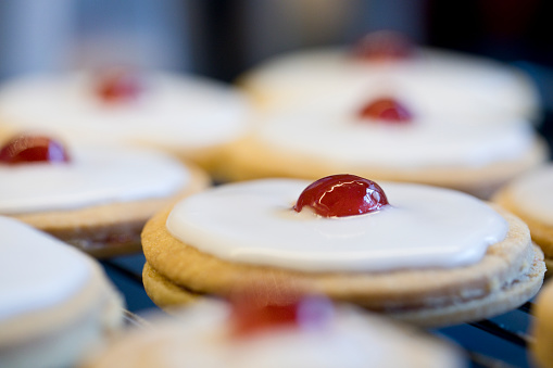 Shortbread biscuits with white icing and a cherry