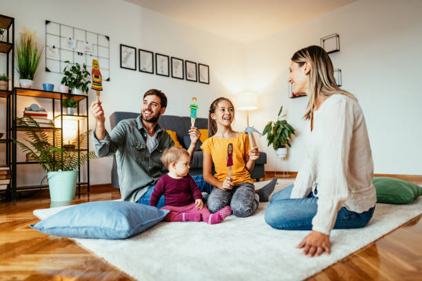 istock Family with two daughters playing at home, making home theatre 1300631336