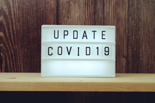 istock Update Covid-19 word in light box on wooden background 1300634142