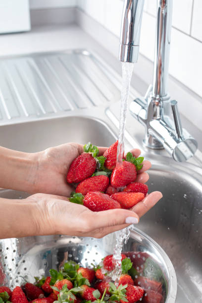 いちごを洗う - washing fruit preparing food strawberry ストックフォトと画像