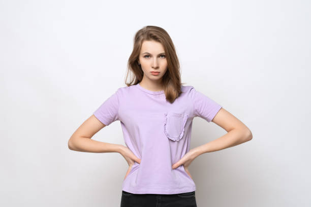 istock frustrated young woman is looking seriously camera with hands on hips. Conflict concept 1300638485