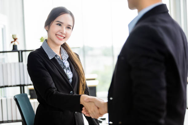 Asian businesswoman and businessman shaking hands at In the office room background after the contract is signed or handshake greeting deal,business expressed confidence embolden and successful concept empresaria y empresaria asiática estrechando la mano en los antecedentes de la sala de oficinas después de que se firma el contrato o acuerdo de felicitación de apretón de manos, el negocio expresó confianza envalentonada y concepto exitoso