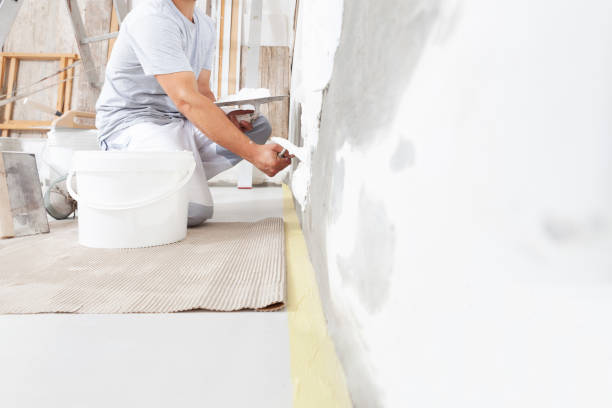 hands man plasterer construction worker at work closeup, takes plaster from bucket and puts it on trowel to plaster the wall, inside the building site of a house - plasterer construction site manual worker plaster imagens e fotografias de stock