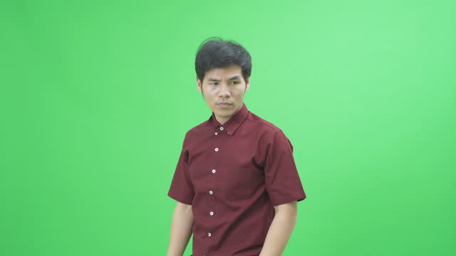 Bad tempered, sad Asian man employee pulling collar and necktie frustrated about work business stressful behaviors gestures isolated on green background. People