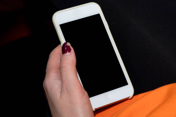 istock A hand with a damaged gel polish holds a smartphone. Record for the procedure. Selective focus. Close-up. 1300641584