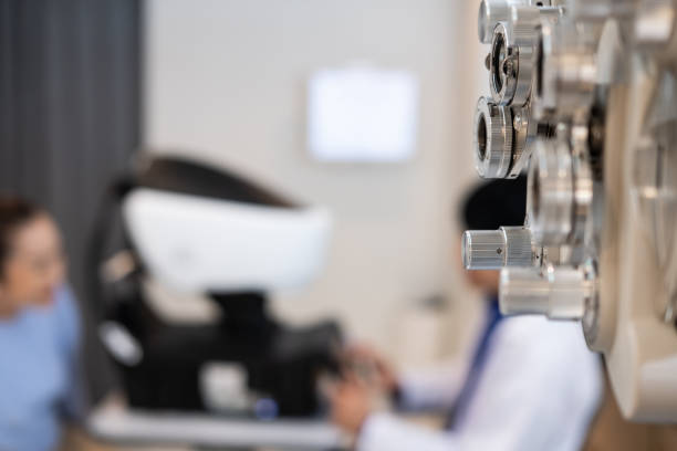 selective focus at optometrist face. while doctor using penlight and subjective refraction to  examine eye visual system of elder patient women with professional machine before made glasses. - penlight imagens e fotografias de stock