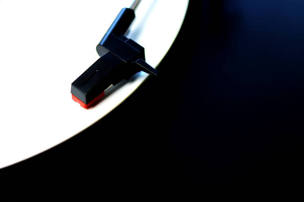 istock White vinyl record spinning on a turntable - gramophone needle - top angle view 1300651891